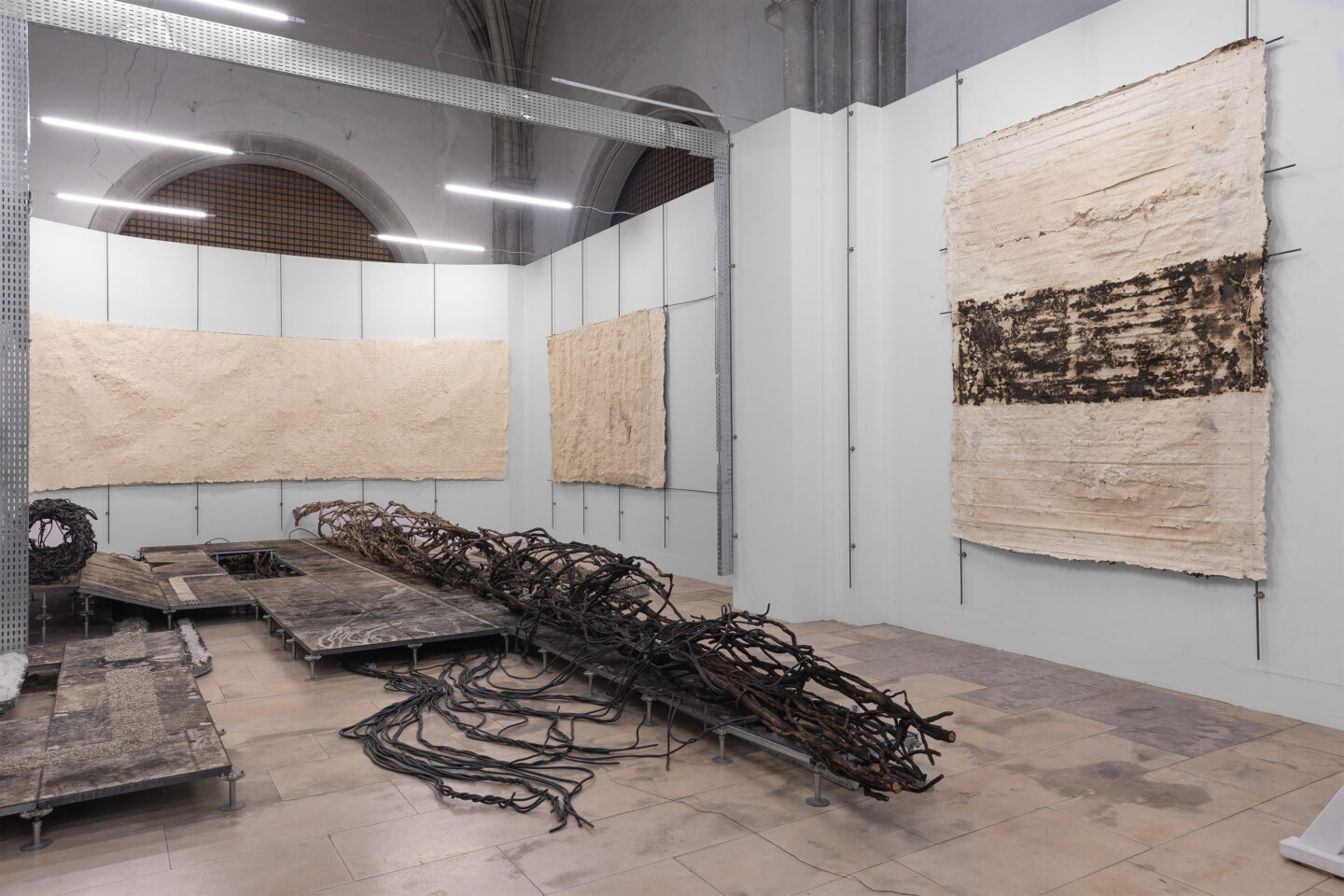 Et que le temps est devenu sourd, 2025, poplar, vines (lierre, ivy), wire, industrial materials, charcoal, Installation at Chapelle des Dames Blanches in La Rochelle,  Photo: Misha Gudwin